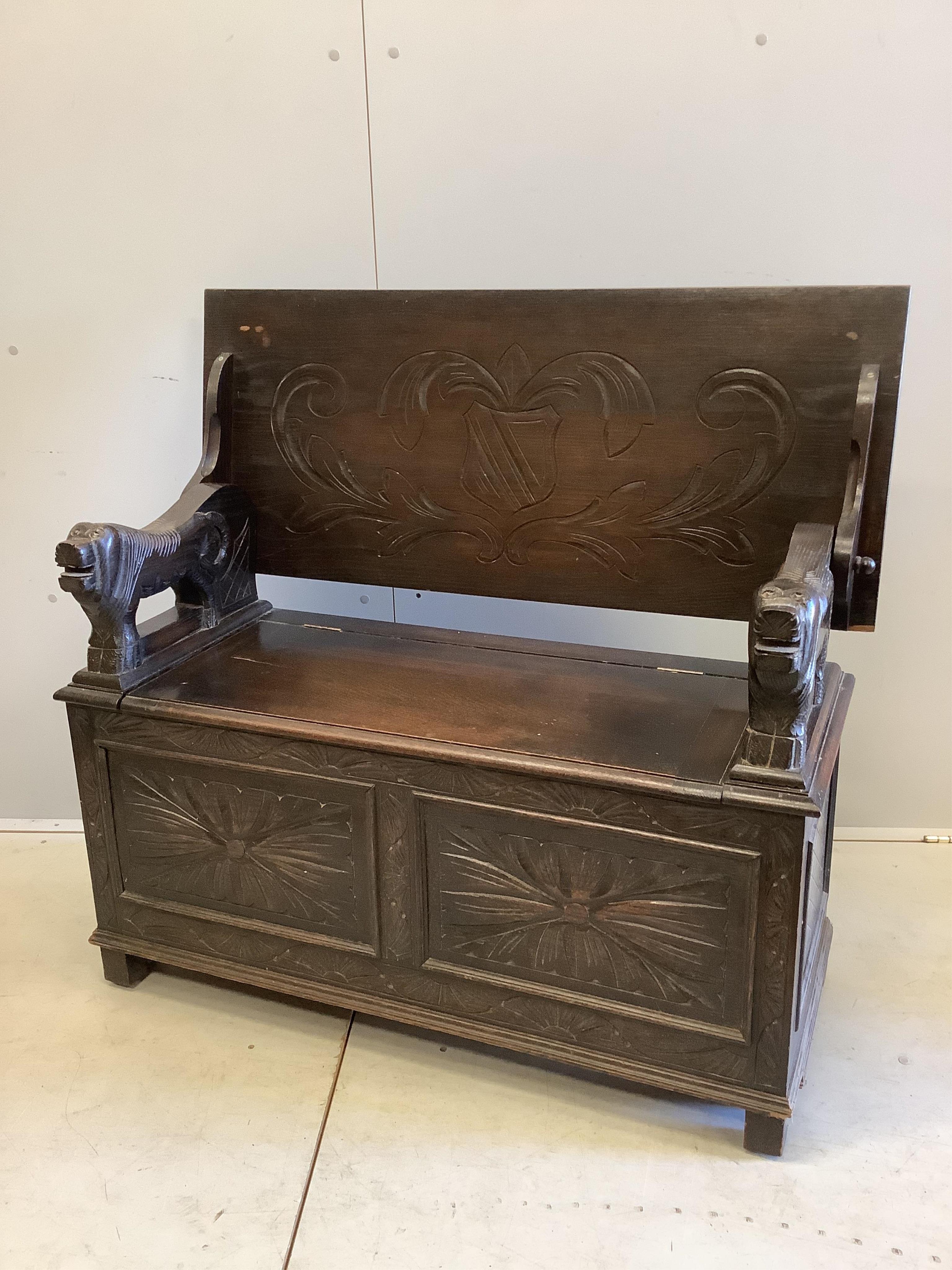 An early 20th century carved oak monk's bench, width 107cm, depth 45cm, height 173cm